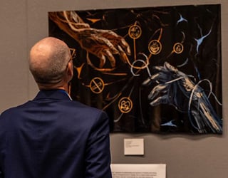 A man views a piece of artwork submitted to the Pain Illuminated art exhibit at the 2025 ASRA Pain Medicine Meeting in Austin, TX.