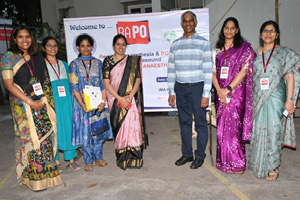 Participants pose in front of the conference sign.