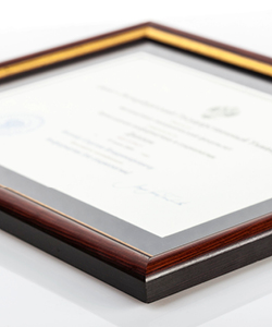 Photo of a certificate in a brown wood frame 